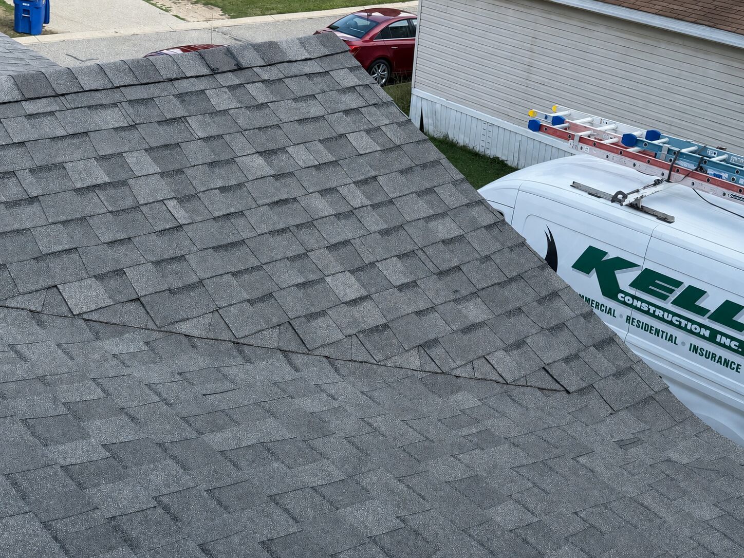 Finished architectural shingle roof, Kelly Construction van in driveway