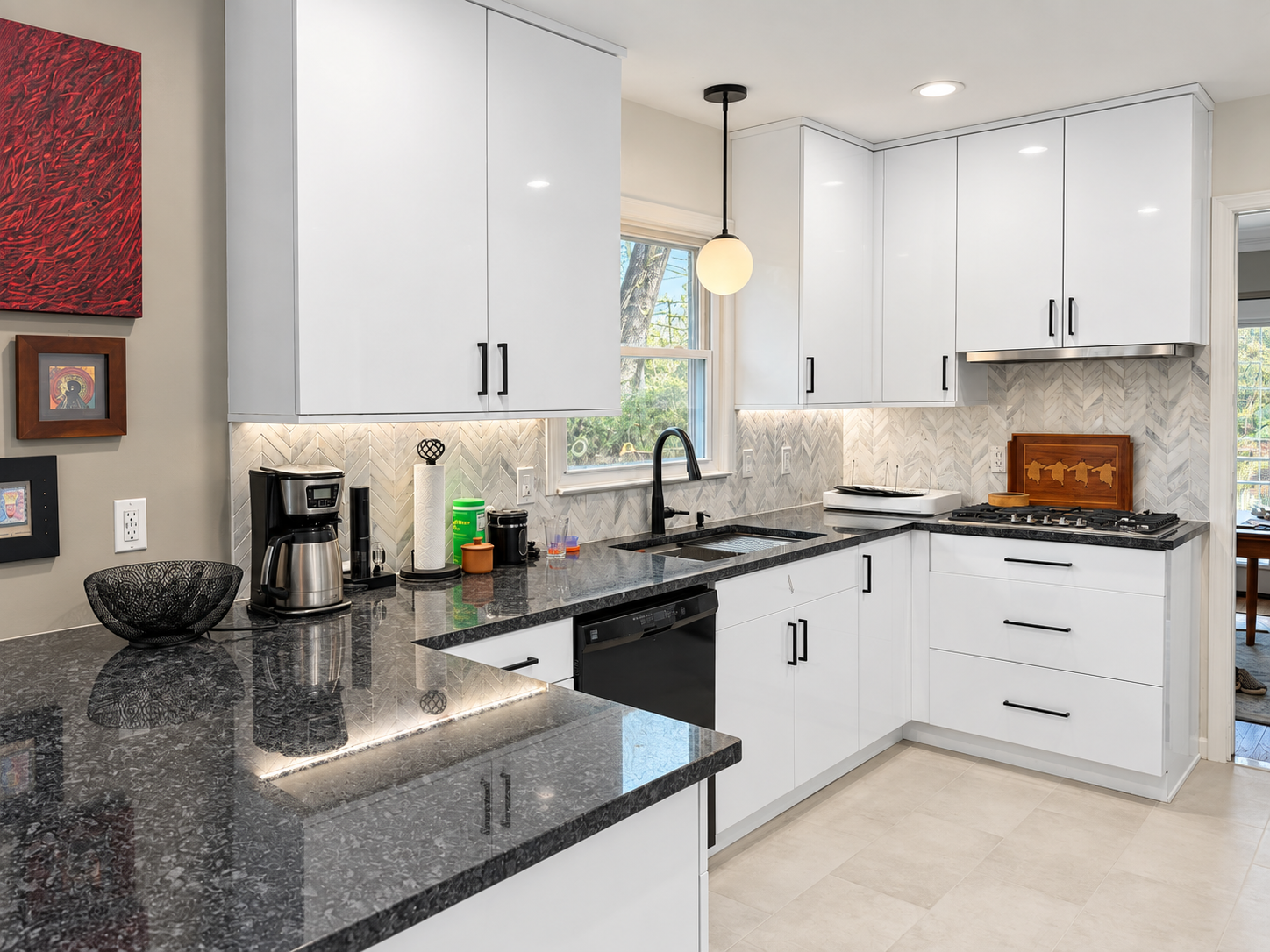 White cabinets, dark counters and herringbone backsplash